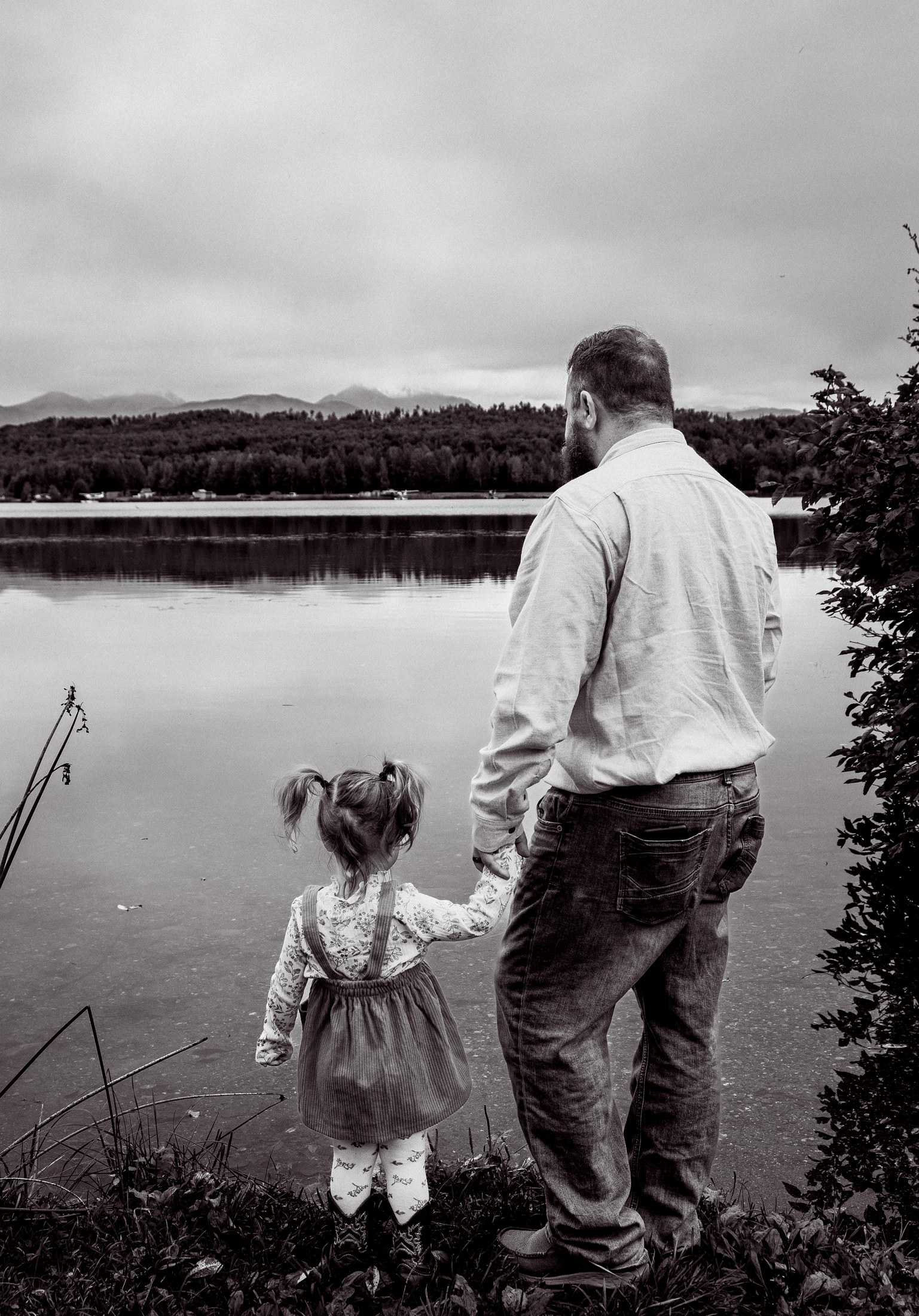 Chris Leutwyler and his daughter looking out over an Anchorage-area lake